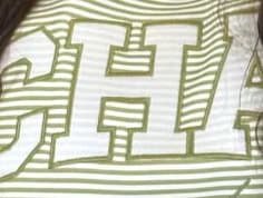 Macro of the embroidered CHAI lettering on the striped knit